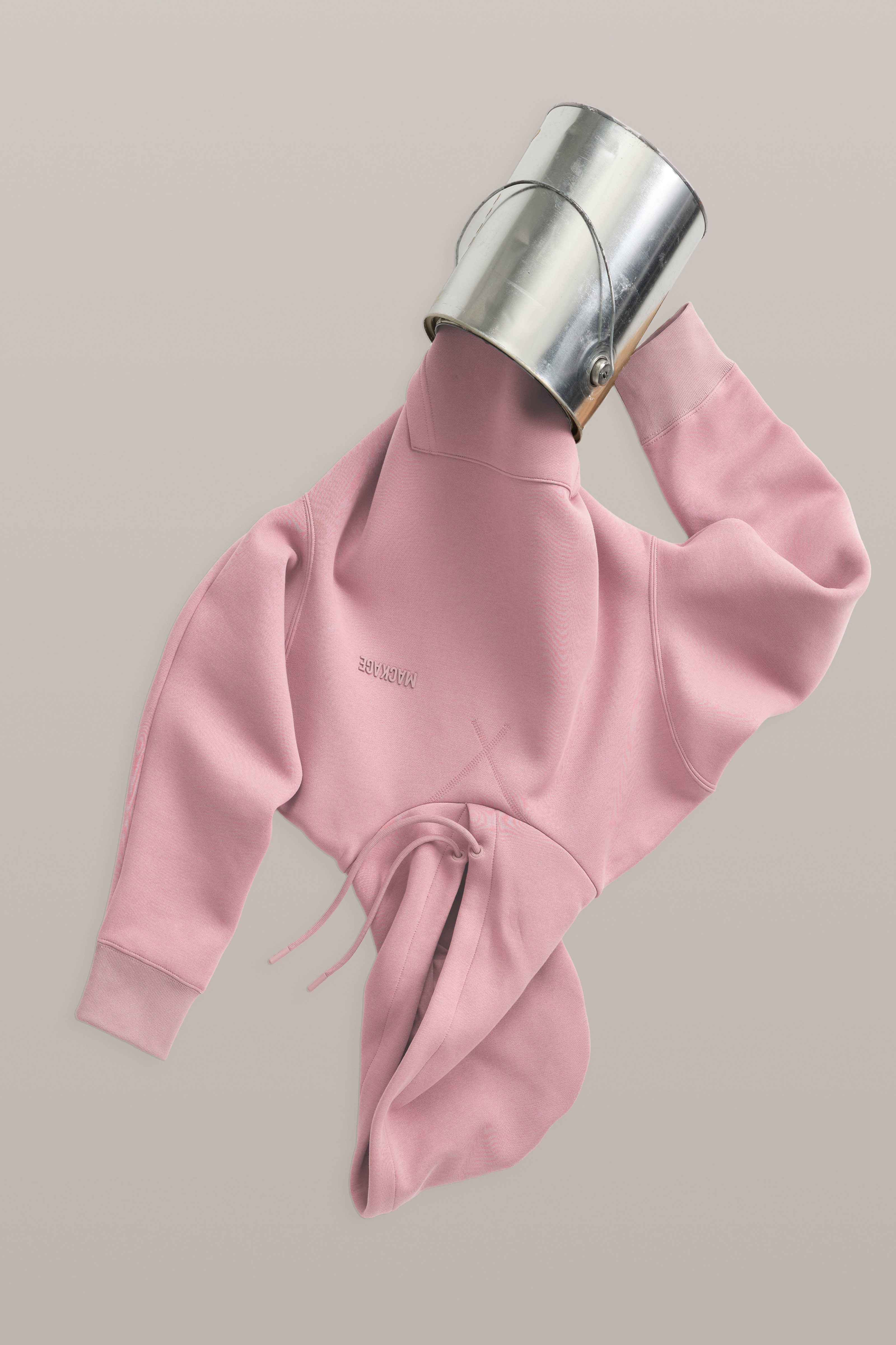 Pink sweatshirt with a metallic can on a beige background